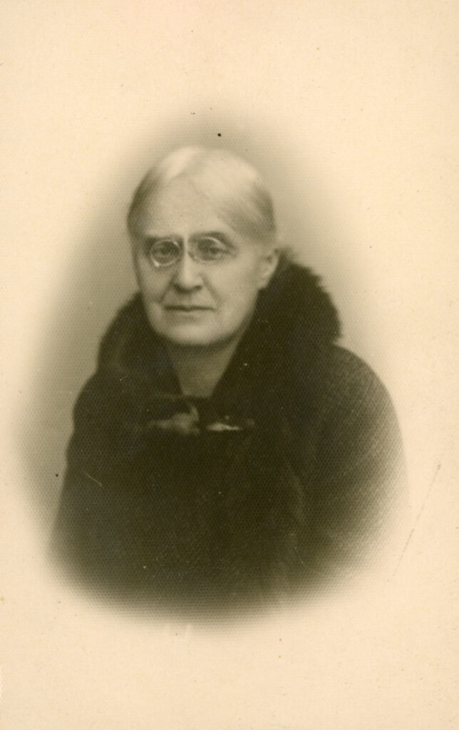 Helena Skłodowska-Szalay, 1945. Zdjęcie z albumu rodzinnego. Ze zbiorów MMSC
Fotografia portretowa przedstawia Helenę Skłodowską-Szalay w 1945 roku, w wieku 79 lat. Sportretowana en face, patrzy ze smutkiem w obiektyw. Ma siwe, gładkie włosy, uczesane do tyłu, z przedziałkiem na środku. Nosi lekko owalne pince-nez w drucianych oprawkach, mocowane na nosie. Jest ubrana w ciemny strój, ozdobiony futrzanym kołnierzem.