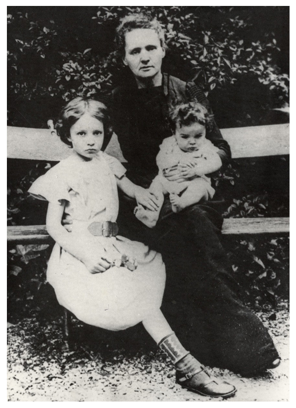 Maria Skłodowska-Curie z córkami, Ireną i Ewą, 1905. Ze zbiorów MMSC
Zdjęcie przedstawia Marię Curie z córkami Ireną i Ewą w 1905. Portretowane siedzą na ławce, na podwórzu ich domu przy bulwarze Kellermanna 108 w Paryżu. W tle krzewy. Irena i Maria, en face, patrzą w obiektyw, niemowlę pochyla się, trzymane przez matkę.
Pierwsza od lewej, Irena, ma ciemne włosy, długości do ucha, uczesane gładko z przedziałkiem na środku. Jest ubrana w jasną, letnią sukienkę, z karczkiem i krótkim rękawem, spiętą szerokim paskiem i sięgającą za kolano. Lewą dłonią Irena przytrzymuje prawą nóżkę Ewy. W prawej dłoni, leżącej swobodnie na podołku, trzyma różę. Prawą stopę, ubraną w sandałek i wzorzystą skarpetkę, wysuwa daleko do przodu, jakby chcąc odgrodzić matkę i młodszą siostrę od fotografa.
Maria prawą ręką obejmuje z tyłu Irenę w pasie, lewą trzyma na kolanie niemowlę. Jest w ciemnej sukni, ozdobionej na rękawach zakładkami. Spod sukni wystaje czubek buta. Jasne, falujące włosy, miejscami siwiejące, ma uczesane do tyłu. Twarz sprawia wrażenie zmęczonej.
Niemowlę w letnim, jasnym ubranku, z rękawami ozdobionymi falbankami, bose, siedzi na kolanach matki. Ma krótkie, ciemne, rozczochrane włosy. Rączkami obejmuje matczyne przedramię.